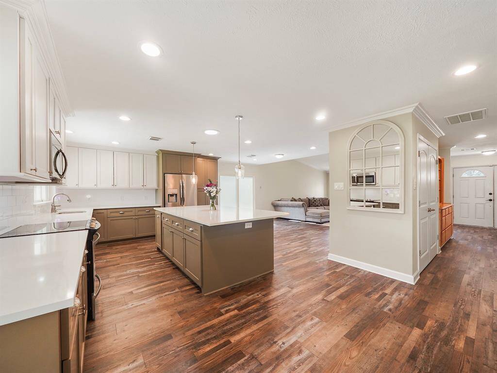 Step inside and be greeted by the sleek, modern ambiance of this inviting home. Laminate floors gleam under recessed lighting, creating a bright and welcoming atmosphere.