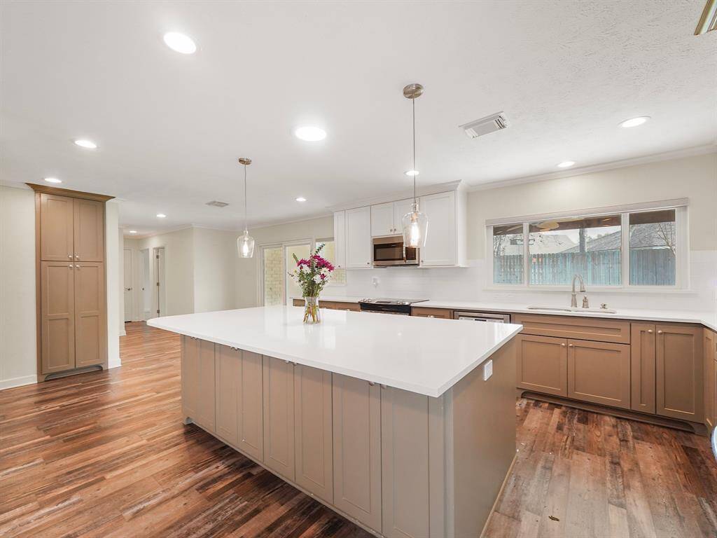 Custom cabinetry provides ample space and a sophisticated aesthetic, while recessed lighting illuminates the area perfectly, creating a warm and inviting atmosphere.