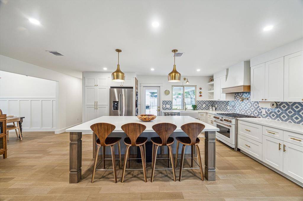 Spacious kitchen with a large, light-filled island and barstool seating.
