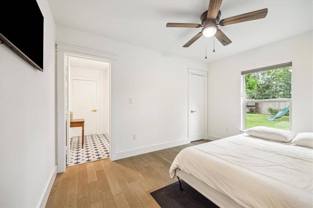 Bright and well-lit bedroom featuring a ceiling fan, abundant natural light, and a built-in Murphy bed that folds away—allowing the space to easily function as an office or multi-purpose room when not hosting guests.