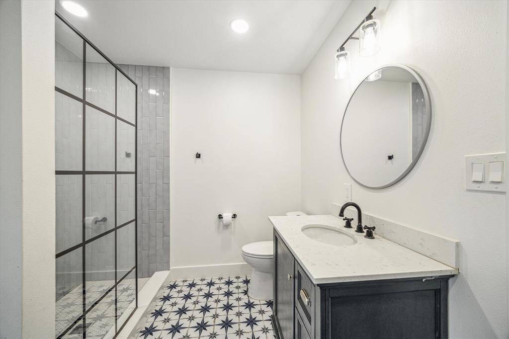 Clean, bright bath offering a modern glass shower enclosure.