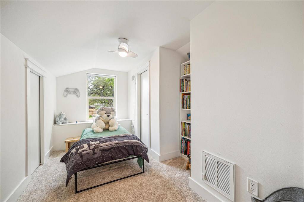 Cozy bedroom with a ceiling fan and ample natural light.