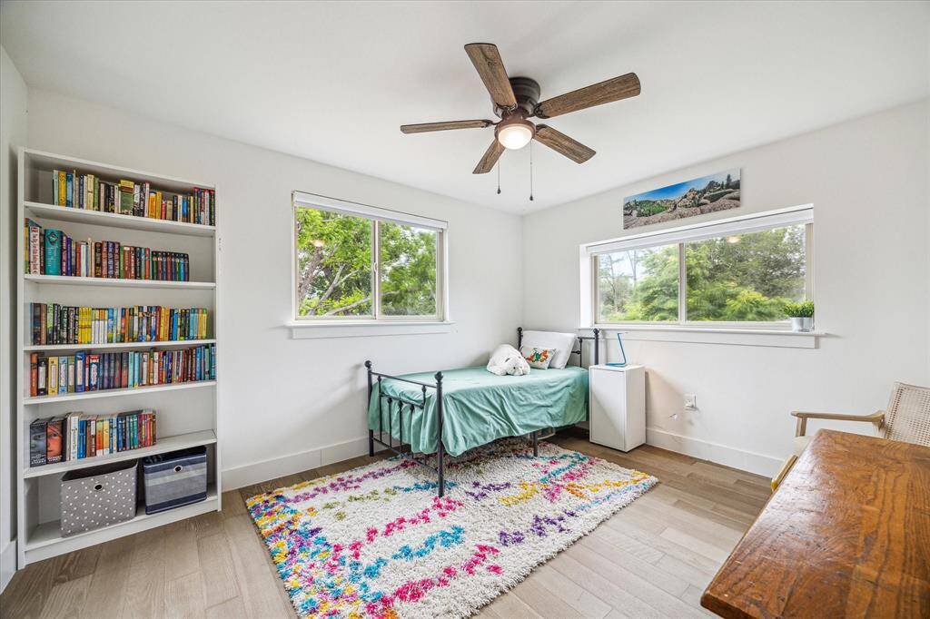 Well-lit bedroom with a ceiling fan and inviting natural light.