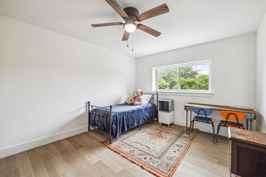 Bright bedroom featuring a ceiling fan and plenty of sunlight.