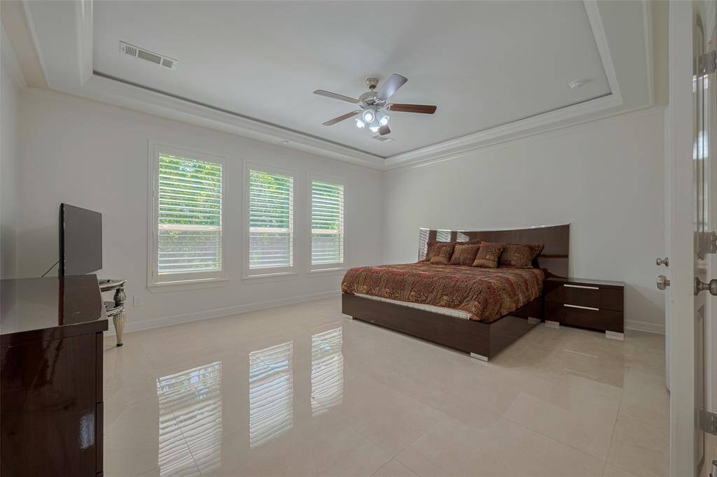 Luxurious- Spacious primary suite that features a wall of windows, tile floors and an elegant tray ceiling!