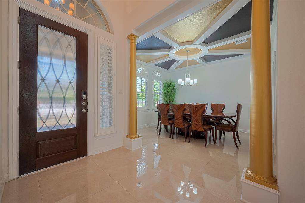 Step through the inviting entry and be greeted by Italian porcelain tile flooring throughout the main level and the formal dining room is a showstopper, with intricate ceiling paneling and plantation shutters!