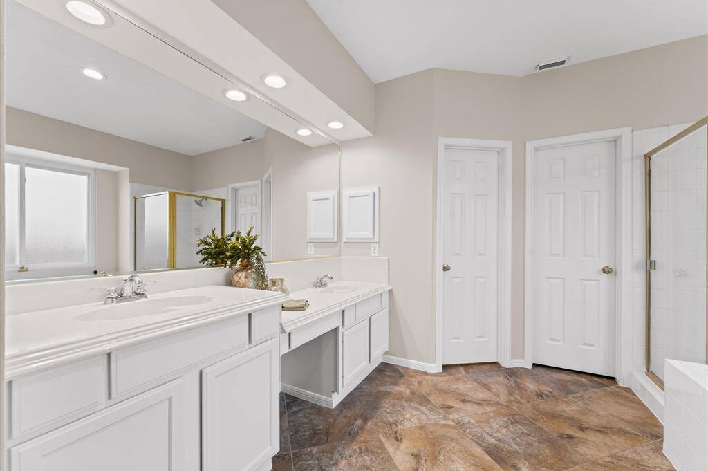 The primary bathroom has separate vanity areas and separate closets.