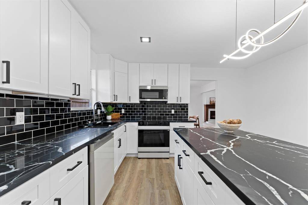 Gorgeous modern kitchen with an oversized island, sleek finishes, ample cabinet space, and a large pantry for storage.