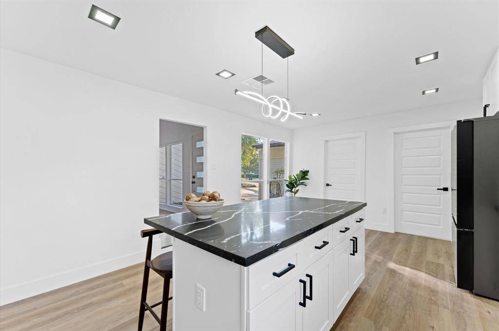 Gorgeous modern kitchen with an oversized island, sleek finishes, ample cabinet space, and a large pantry for storage.
