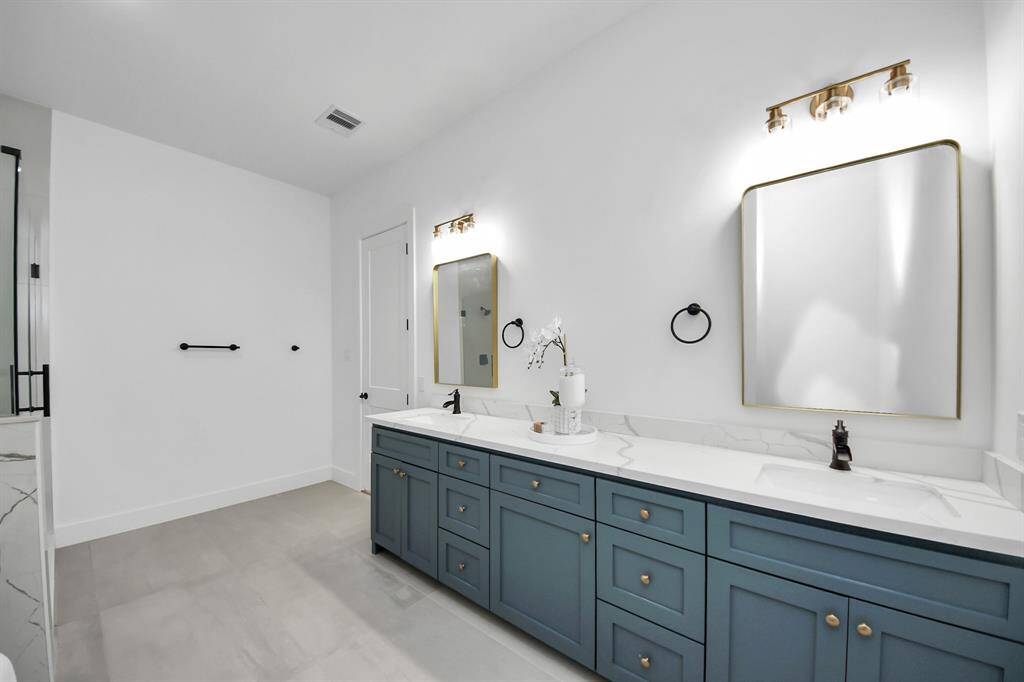 The primary bathroom features dual sinks, light countertops, freestanding tub, and separate shower.