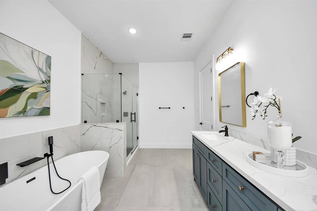 The walk-in shower has a glass door.