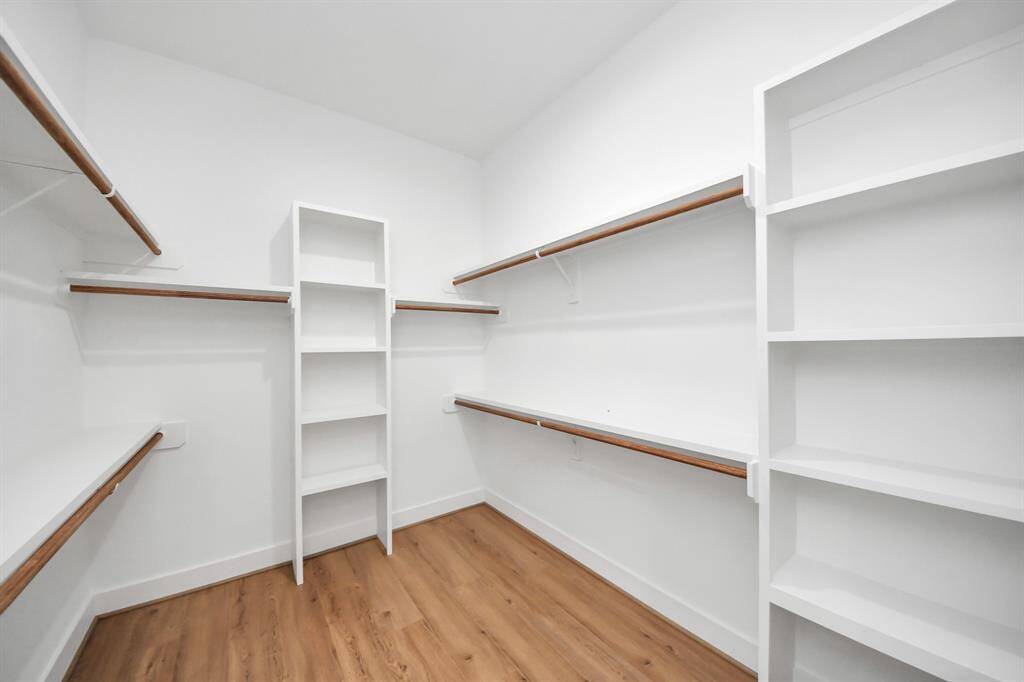 The expansive walk-in closet has built-in shelving and plenty of storage space.