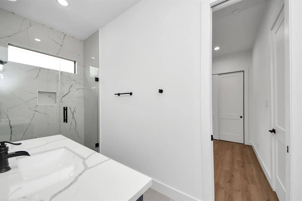 Secondary bathroom features a walk-in shower with tile surround and spacious vanity.