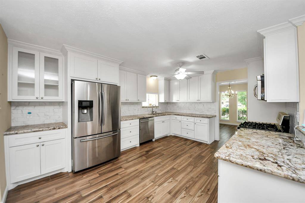 Spacious kitchen featuring stainless steel appliances, abundant counter space, ample cabinetry, and a bright, inviting breakfast area