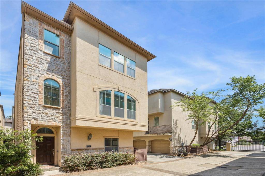 574 Bomar Street, a beautifully maintained corner unit tucked inside a secure, gated enclave in the heart of Montrose. A charming mix of stone and stucco adds warmth to the exterior, while oversized windows hint at the natural light that fills the interior spaces. Manicured landscaping and a private entry create a gracious first impression.