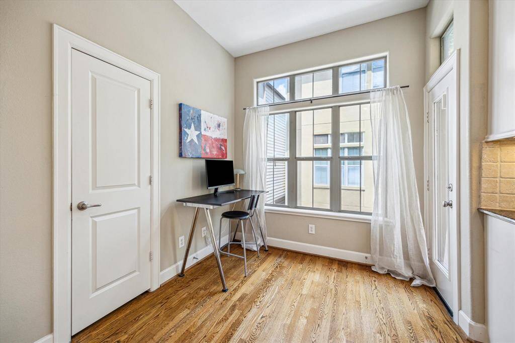 Just off the kitchen, a sunny nook with oversized windows and patio access creates the perfect spot for a home office or quiet coffee corner.