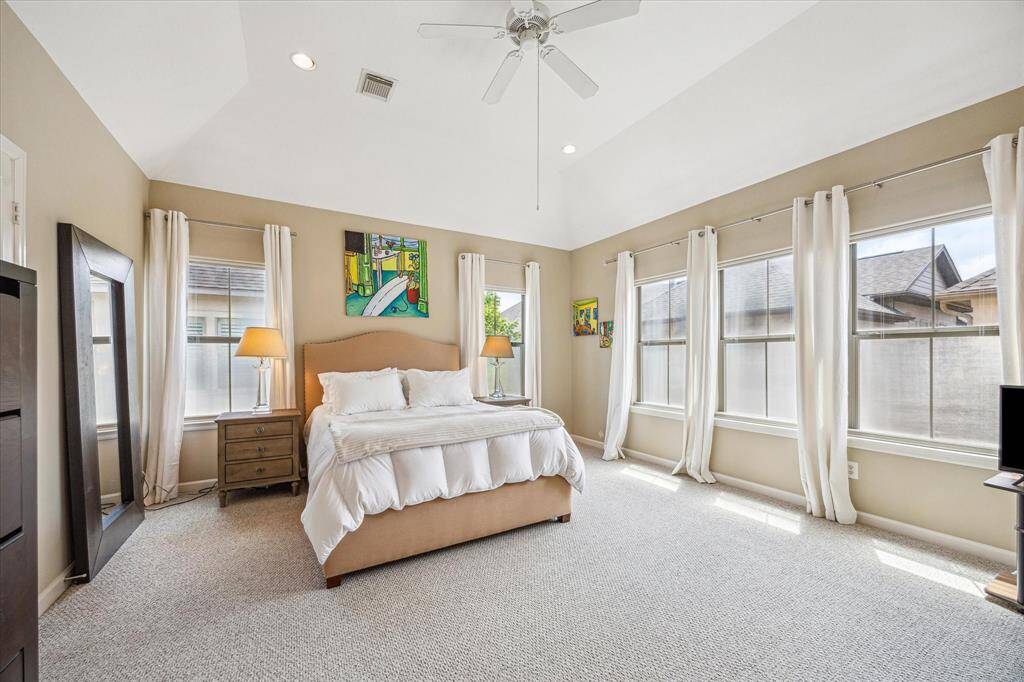 Vaulted ceilings and walls of windows fill the spacious primary suite with natural light, creating a peaceful, airy retreat on the top floor.