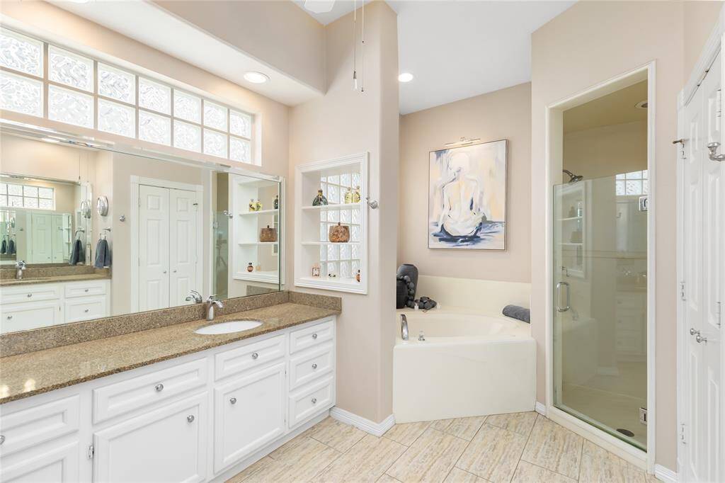 Further bathroom amenities include a jetted tub and an updated solid glass door for the walk-in shower.