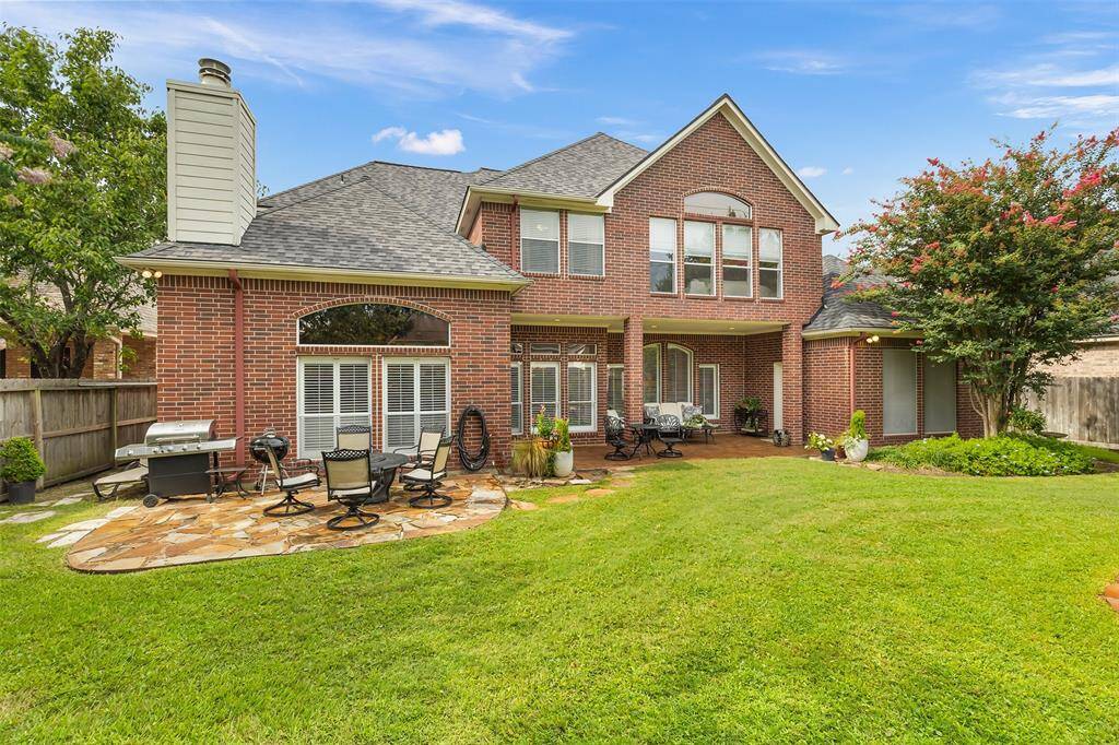 Once outside you'll find the park-like backyard, with a flagstone patio under the grill and dining set.