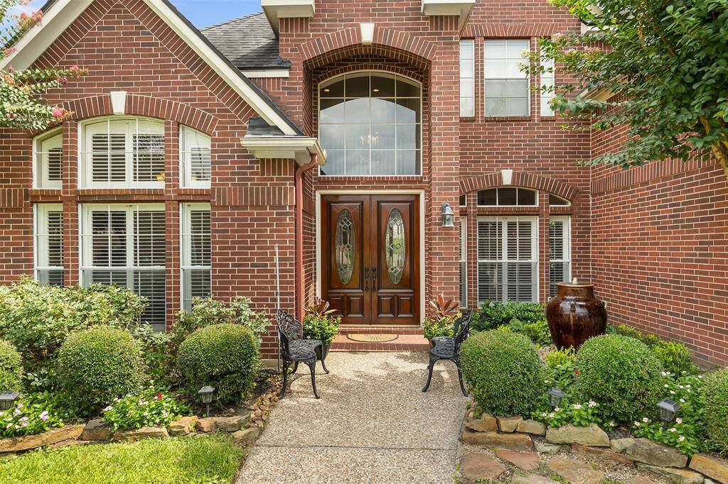 Walking up to the glass-set mahogany double doors you'll see the lush landscaping and water fountain