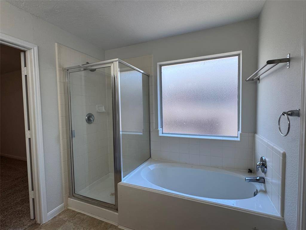Primary bath has shower stall and tub
