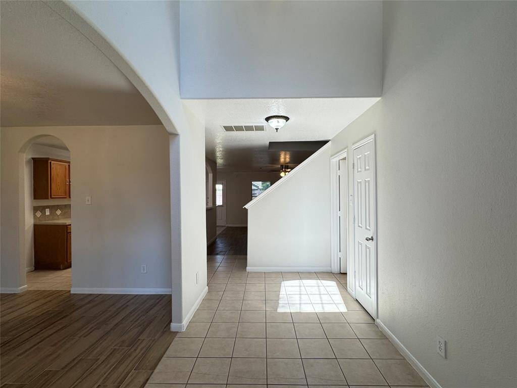 Grand entrance with coat closet and laundry room on the right, formal dining room on the left, living room and kitchen beyond