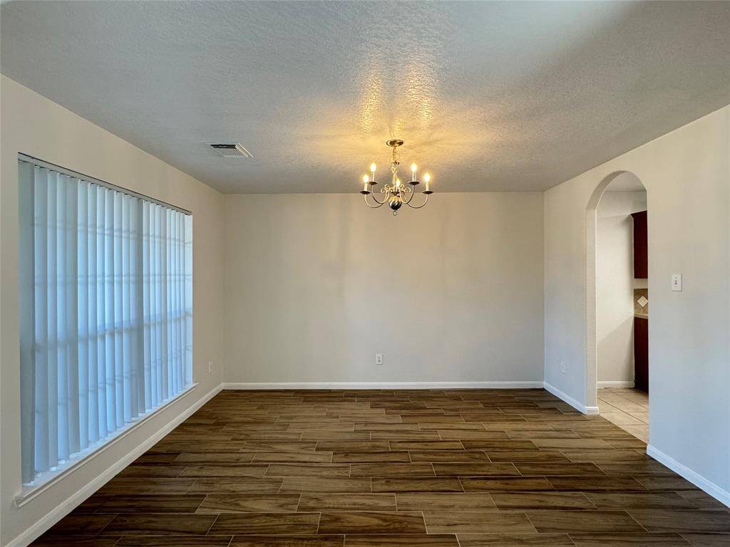 Lovely formal dining room with NEW wood-looking tile and view of front porch to the left