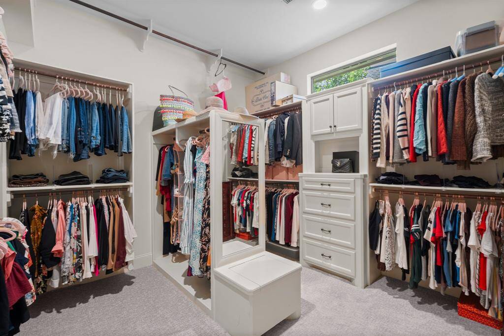 Spacious walk-in closet with ample hanging space, built-in drawers, and shelving.