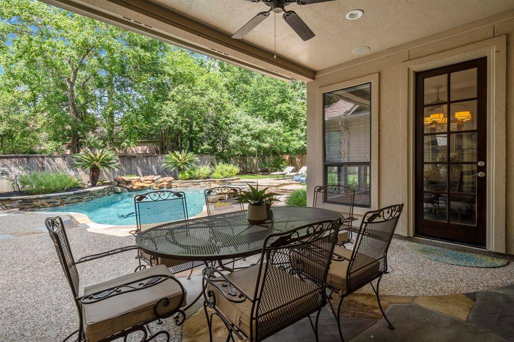 Covered patio overlooking serene backyard.