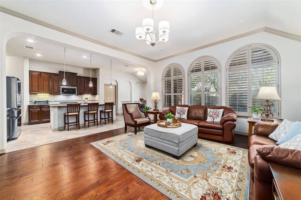 Spacious open floor plan featuring a kitchen with breakfast bar, seamlessly connected to the family room. Enjoy elegant plantation shutters and stunning hardwood floors.