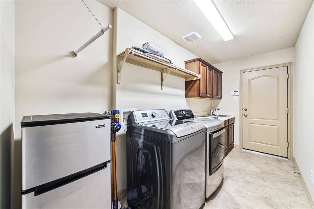 Spacious utility room with a convenient sink, space for an extra fridge