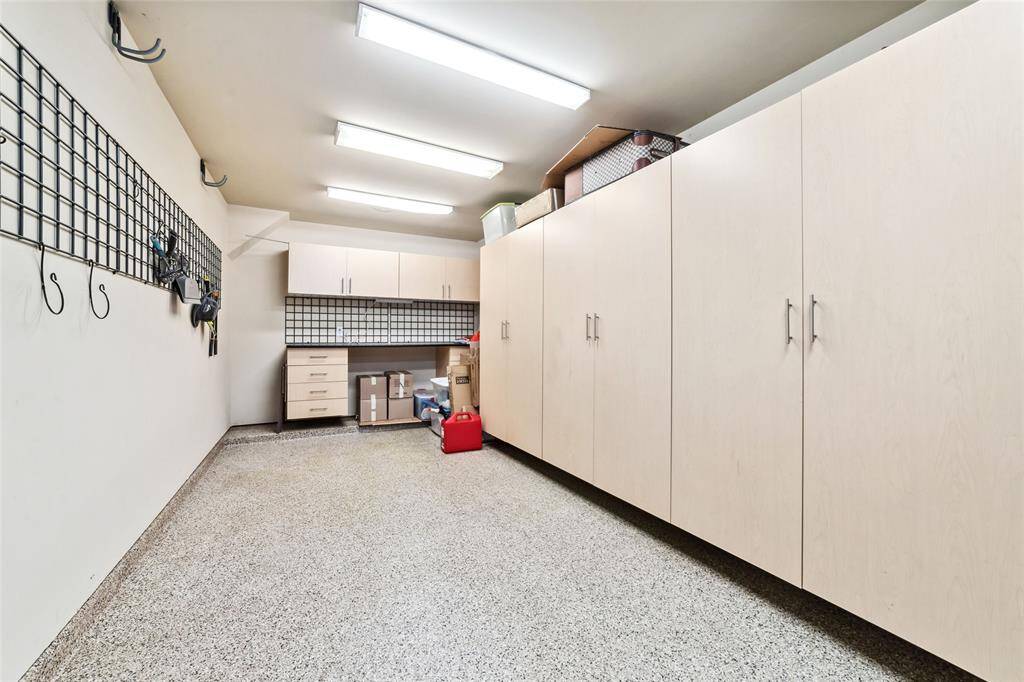 Spacious tandem garage with built-in storage cabinets and a convenient workshop area.