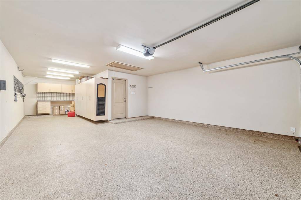 Spacious three-car garage featuring sleek epoxy flooring—perfect for your vehicles and extra storage.