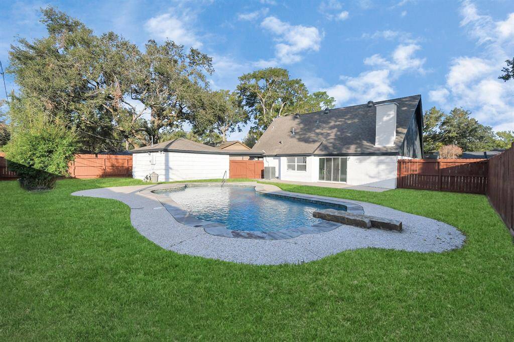 Welcome to 6035 Cartagena! An aerial view showcases the magnificent pool, surrounded by elegant stone coping and featuring a unique stone diving board, creating a striking focal point in the backyard. Just in time for summertime!