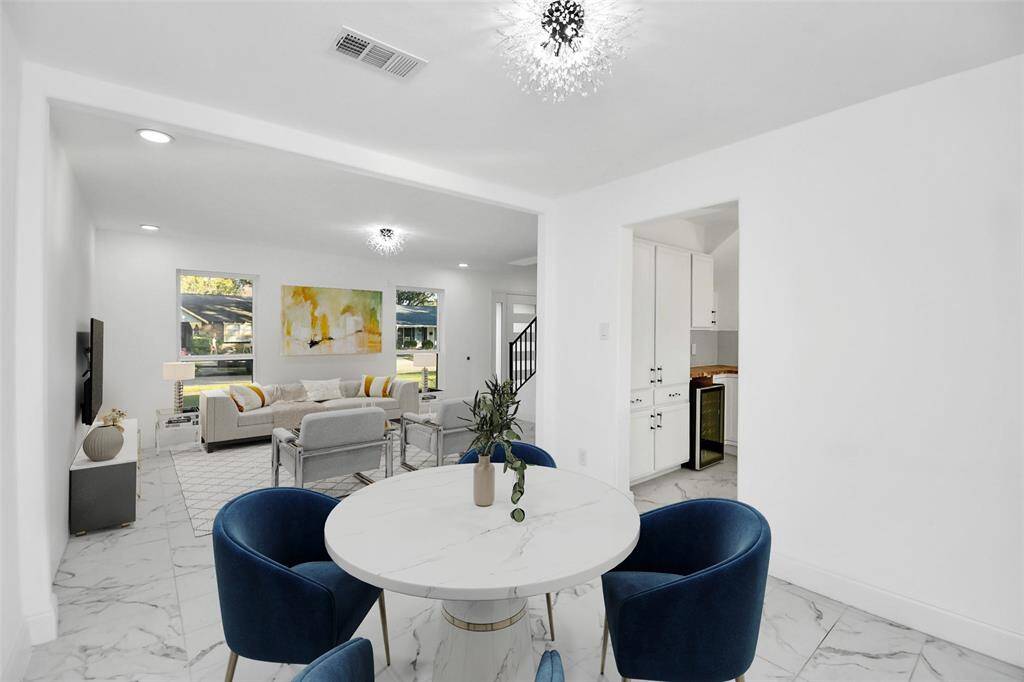 Just off the entry, a versatile space awaits, perfect as a formal living room or study. It features elegant marble subway tile flooring and new double-pane windows. (Virtually Staged)