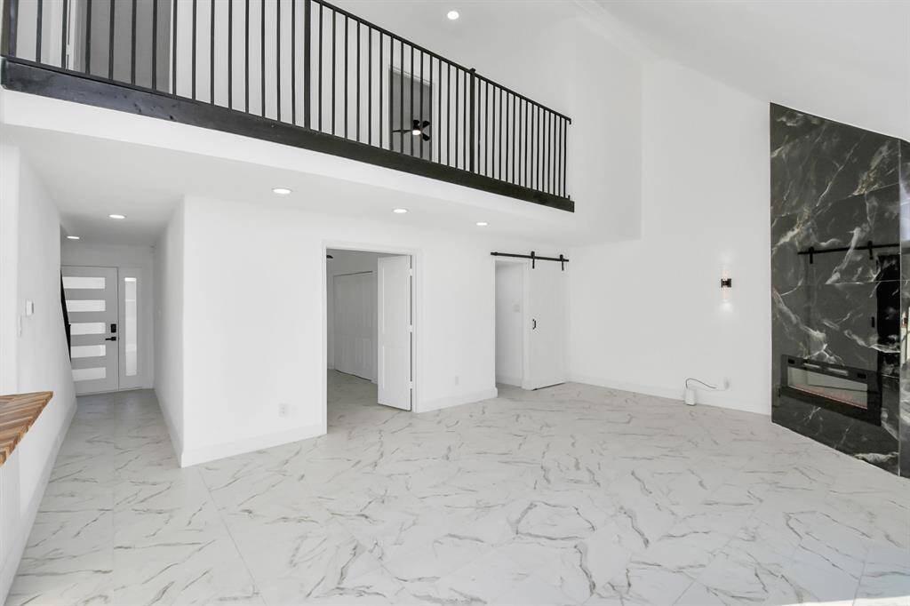 A wrought iron railing accents the catwalk, enhancing the home's architectural charm and overall appeal.