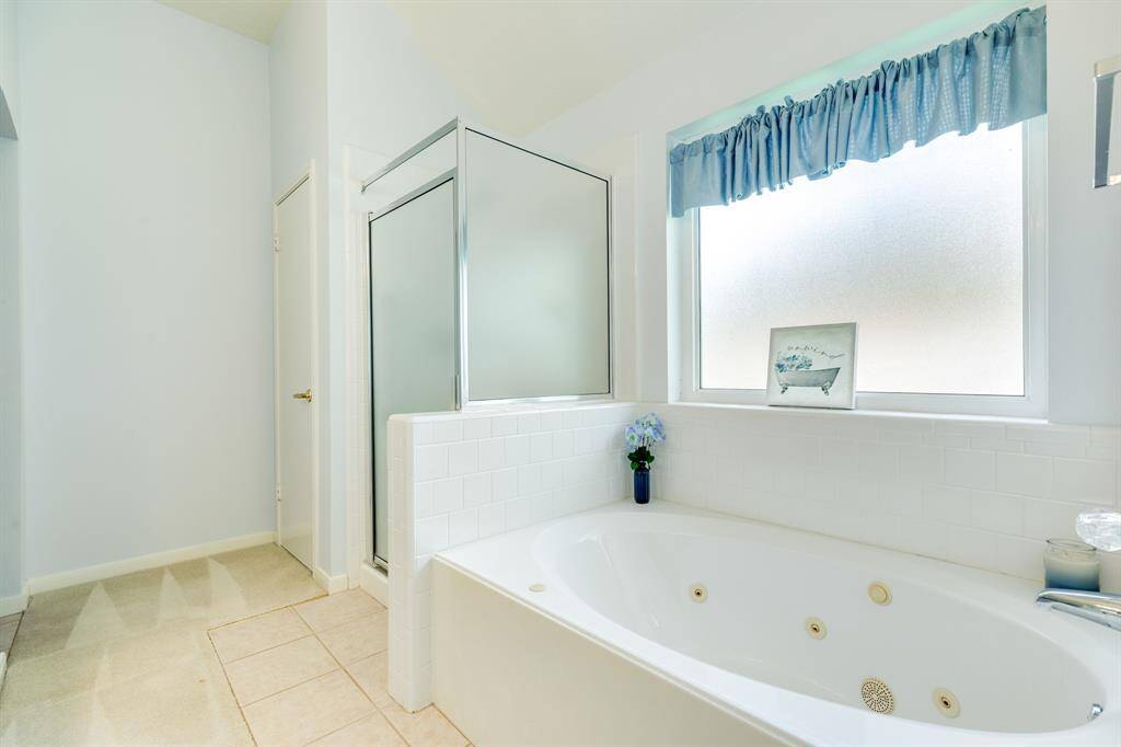 Primary ensuite bath with a large walk-in closet, dual sinks, jacuzzi tub, walk-in shower.