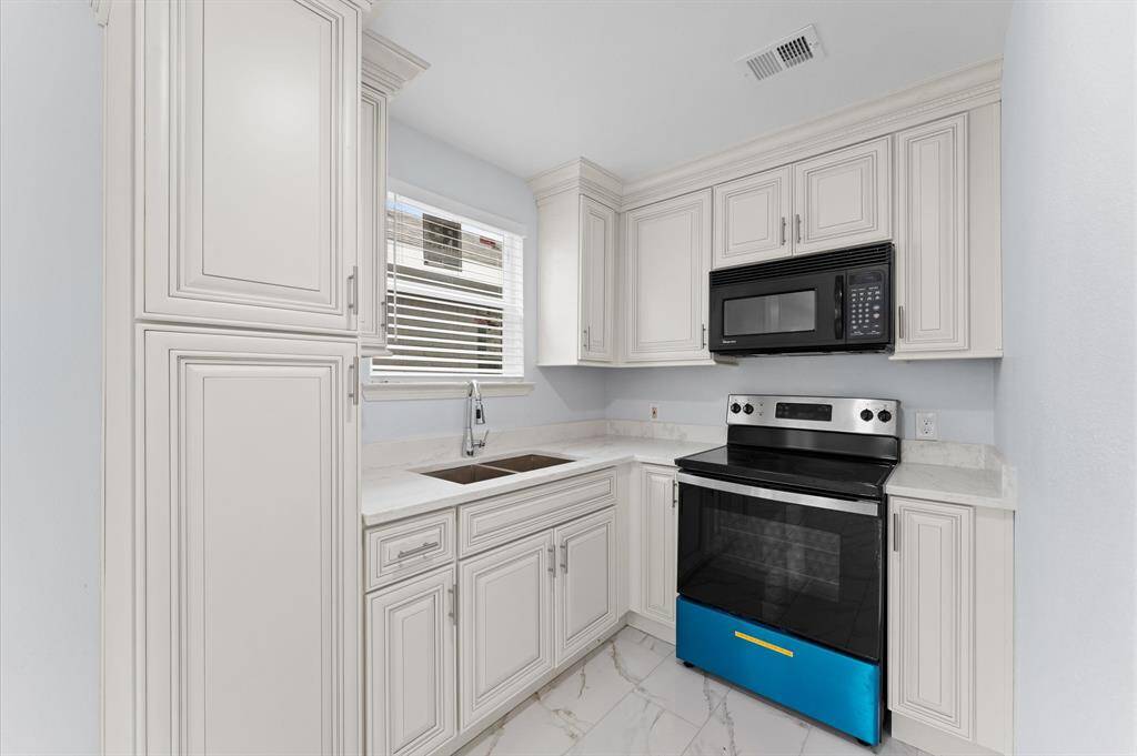 Full kitchen with stove and microwave in apartment 1.