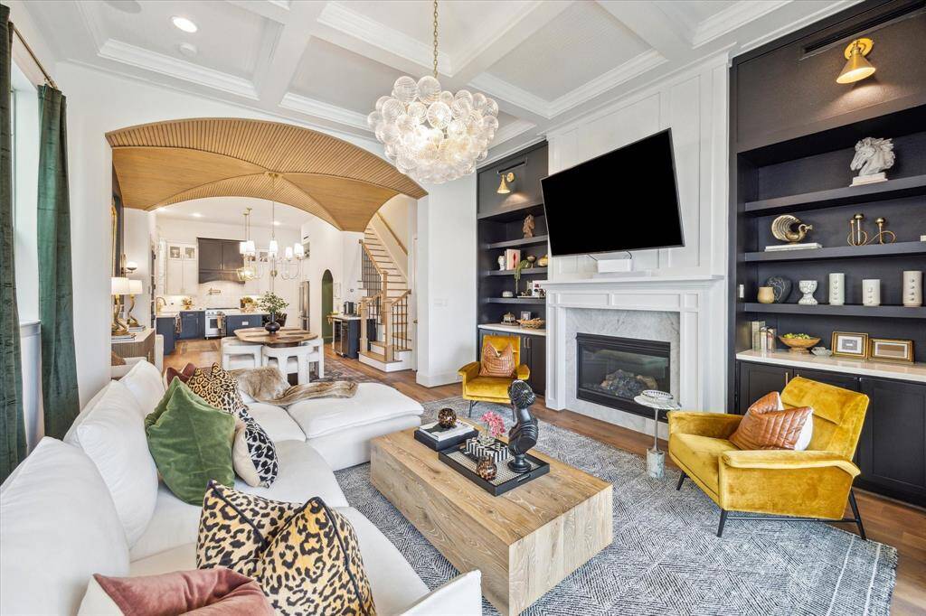 Fireplace and built-in shelves with a chic chandelier and has a seamless flow into the dining area and kitchen.
