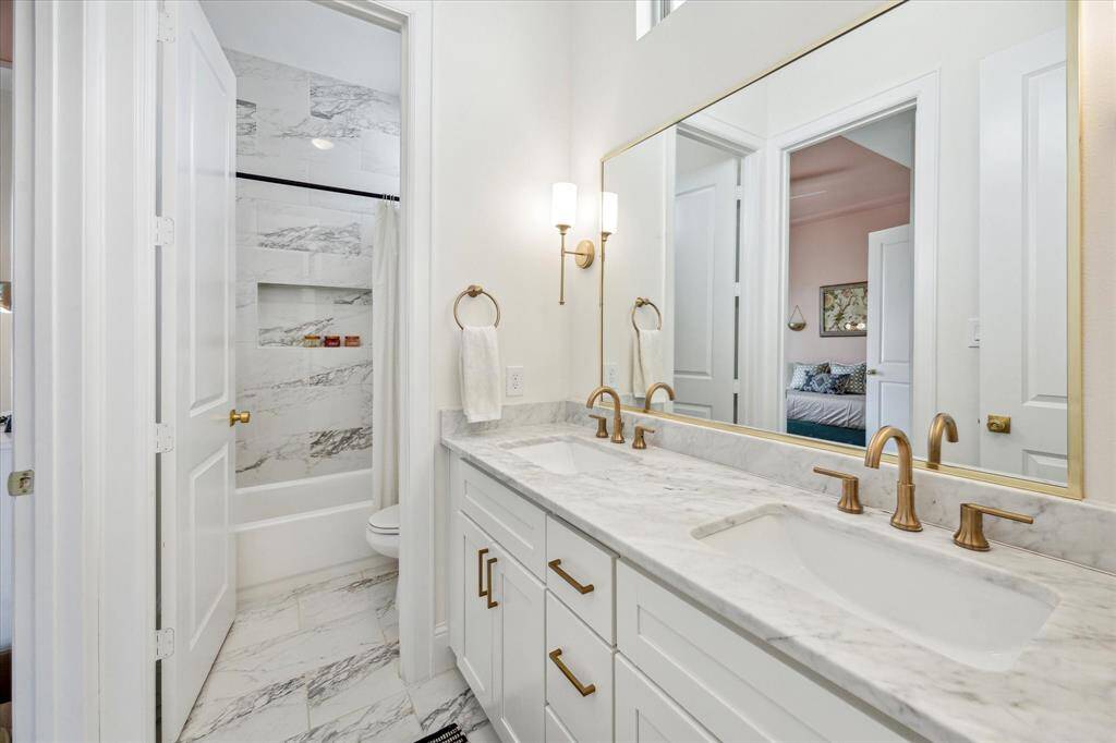 En-suite bathroom featuring a double vanity with beautiful fixtures.