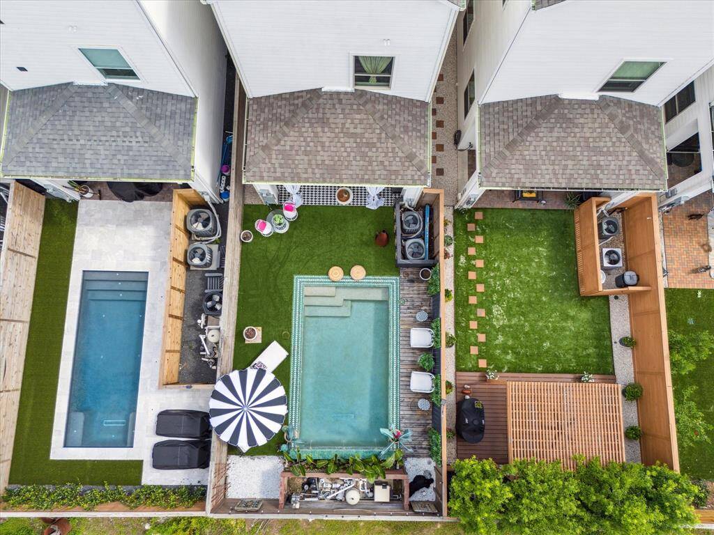 Central self cleaning swimming pool, surrounded by turf and a stylish seating area