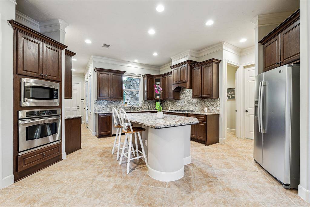 Gourmet island kitchen with ample storage, stunning stone countertops, and a spacious layout.