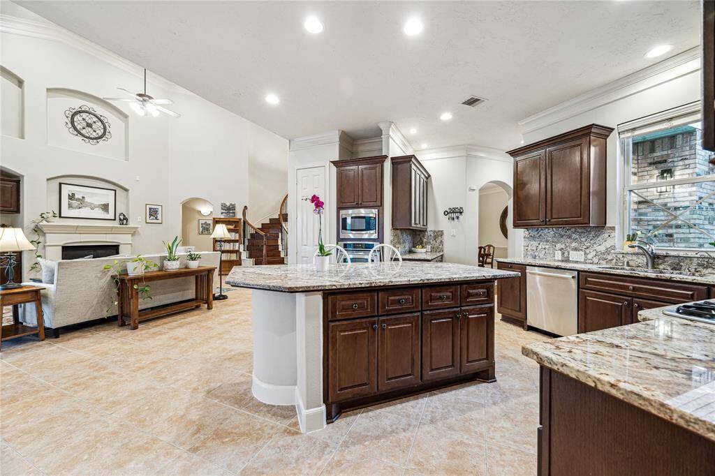 Open-concept kitchen featuring sleek stainless steel appliances, generous counter space, and bar seating at the island.