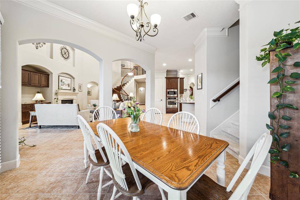 Back inside, the sunny breakfast room offers cozy views of the backyard and easy access to the kitchen—alongside a convenient second staircase for added functionality and flow throughout the home.