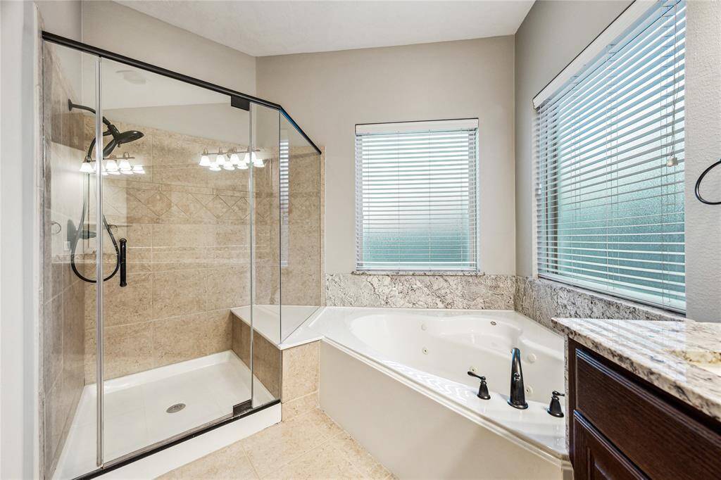 Relaxing soaking tub paired with a spacious glass shower, both featuring privacy windows that allow natural light to fill the space.