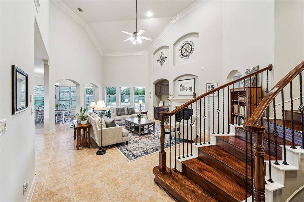 Inviting view of the family room with its open, airy layout, highlighted by the dramatic staircase with wrought iron railings.
