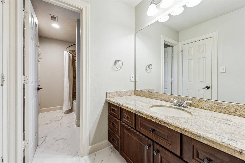 Convenient Hollywood bath featuring a single vanity, shared by two bedrooms.