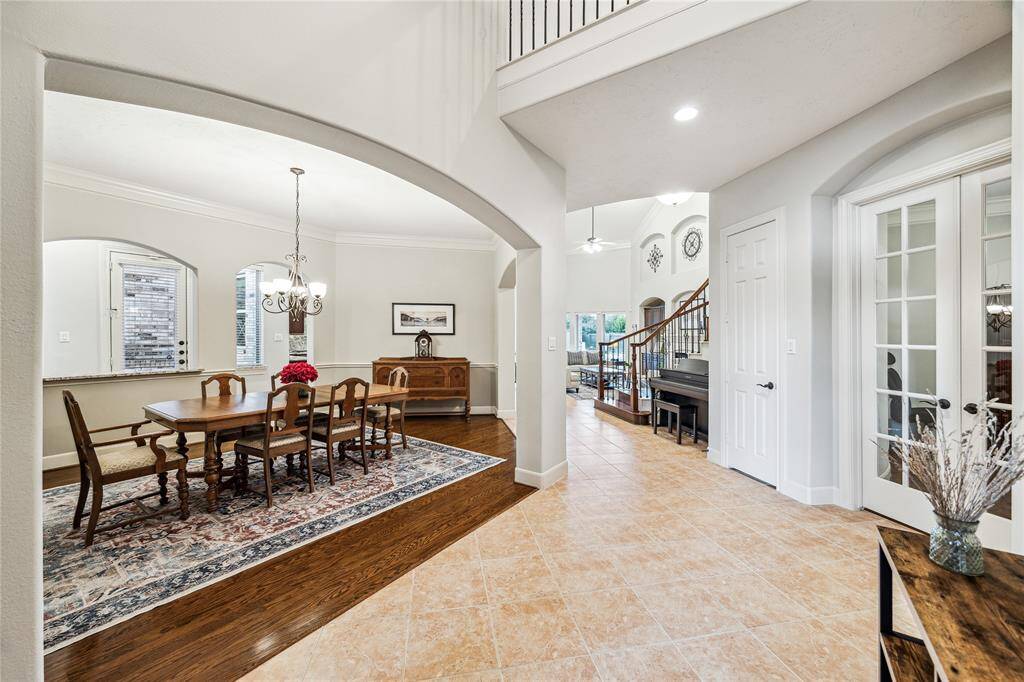 Elegant entryway with arched openings leads to the formal dining room, featuring direct patio access.