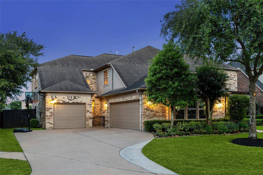 Unique three-car garage configuration with two spaces side-by-side and a third separate bay, offering plenty of room for vehicles, storage, or a workshop. The garages are thoughtfully separated by a patio, creating both function and an inviting outdoor space.