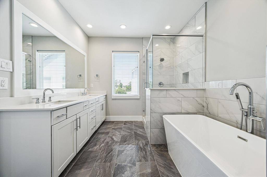 The primary bathroom features dual sinks, a separate shower and soaking, and plenty of under sink storage.